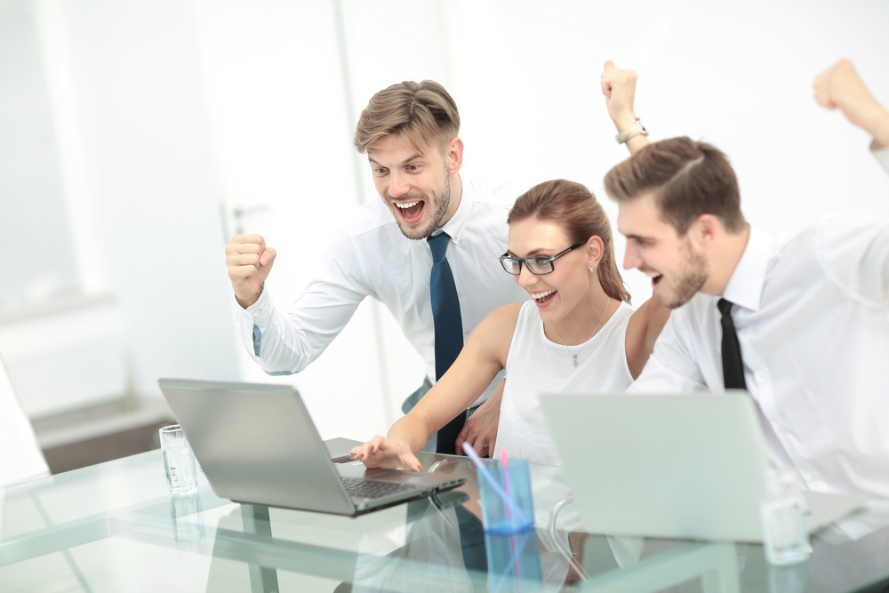 Business team getting excited about marketing results on their laptop