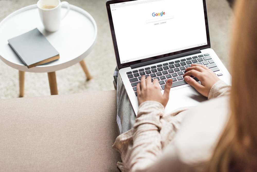 A woman is performing a search on a laptop