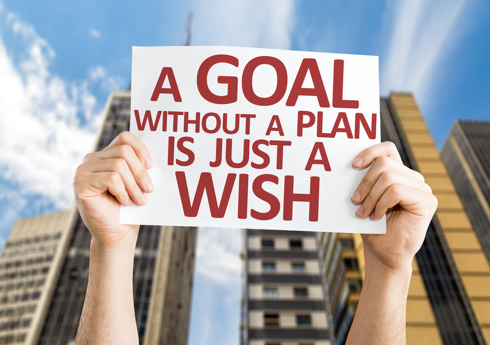 A sign being held stating a goal without a plan is just a wish